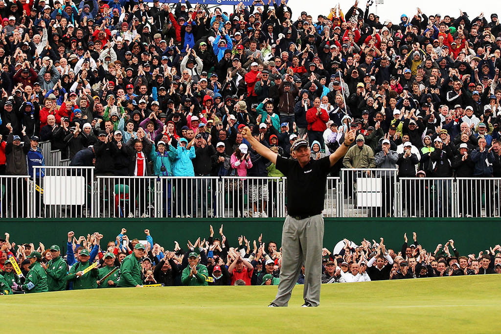 The crowd rises to celebrate Darren Clarke winning The Open